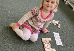 dziecko konstruuje litery i wyrazy z klocków- przygotowanie do nauki czytania i pisania